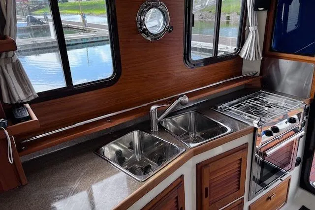 Slide: The Image of Interior of 2021 Ranger Tugs R-31 CB featuring a modern kitchen with dual sinks and stove. - 45