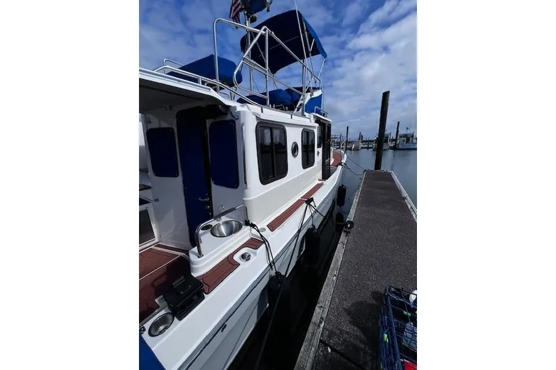 Slide: The Image of 2021 Ranger Tugs R-31 CB docked at marina under blue sky. - 5