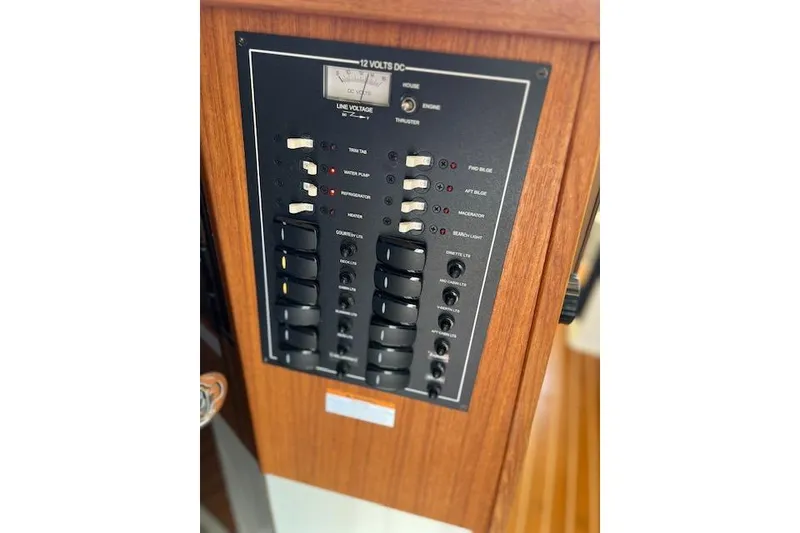 Slide: The Image of Control panel of 2021 Ranger Tugs R-31 CB boat, featuring switches and voltage meter. - 58