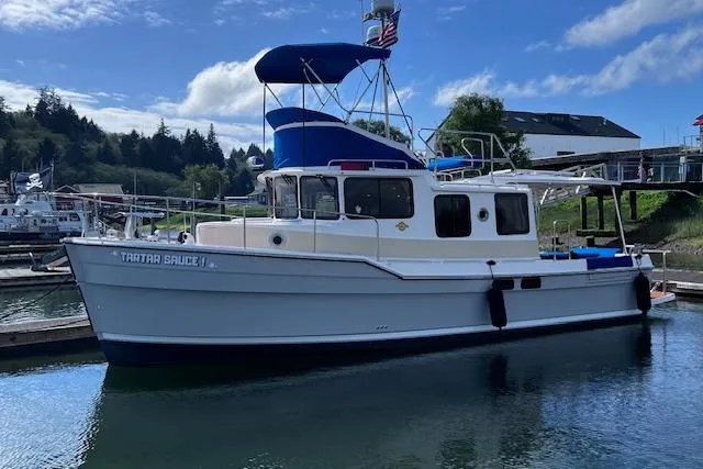 Slide: The Image of 2021 Ranger Tugs R-31 CB boat docked in a scenic marina setting. - 6