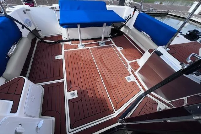 Slide: The Image of 2021 Ranger Tugs R-31 CB boat deck with blue seating and wood finish. - 60