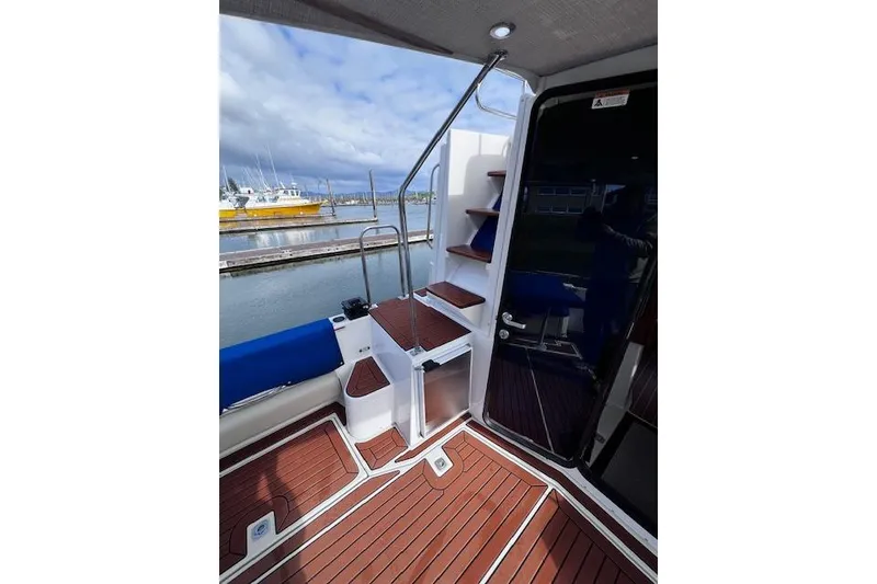 Slide: The Image of 2021 Ranger Tugs R-31 CB boat deck with wooden flooring and marina view. - 63