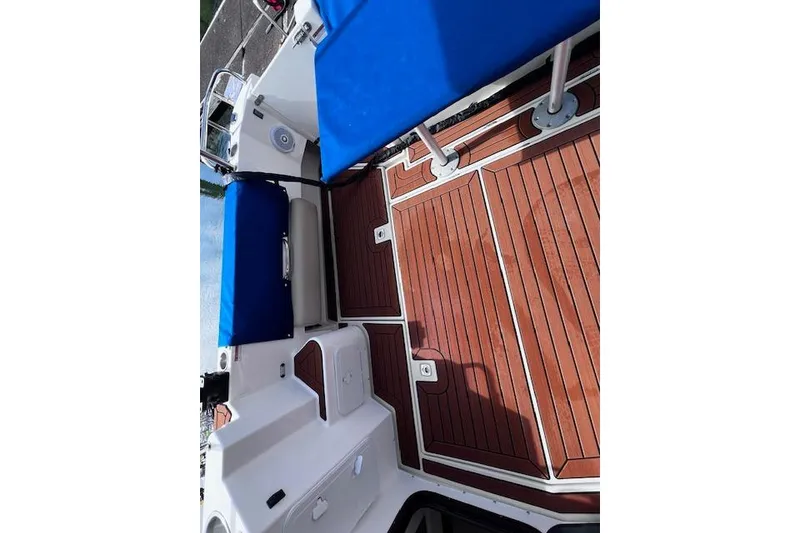 Slide: The Image of 2021 Ranger Tugs R-31 CB boat deck with blue seating and wooden flooring. - 64