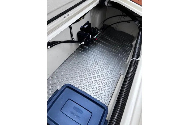 Slide: The Image of 2021 Ranger Tugs R-31 CB storage compartment with diamond plate flooring and blue storage bin. - 72