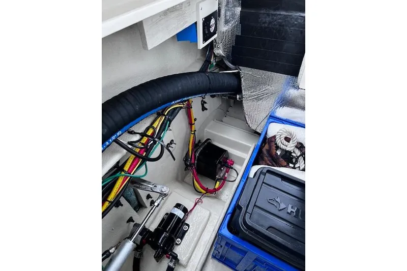 Slide: The Image of Engine compartment of 2021 Ranger Tugs R-31 CB with wiring and storage boxes. - 76