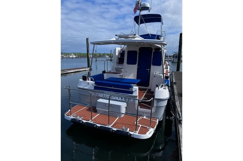 Slide: The Image of 2021 Ranger Tugs R-31 CB docked, featuring a spacious deck and blue accents. - 8