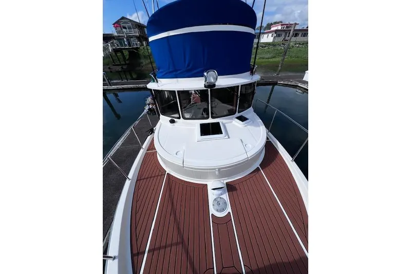 Slide: The Image of 2021 Ranger Tugs R-31 CB boat with blue canopy, docked in marina. - 9