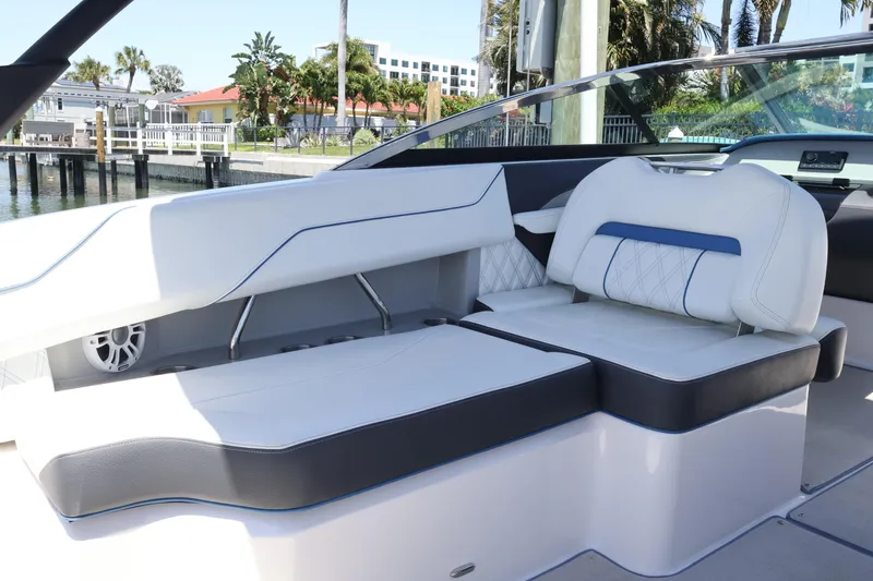 Slide: The Image of 2020 Regal LX4 boat interior with white and blue seating, dockside view. - 16