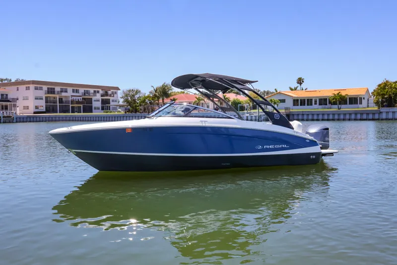Slide: The Image of 2020 Regal LX4 boat on calm water with residential backdrop. - 3