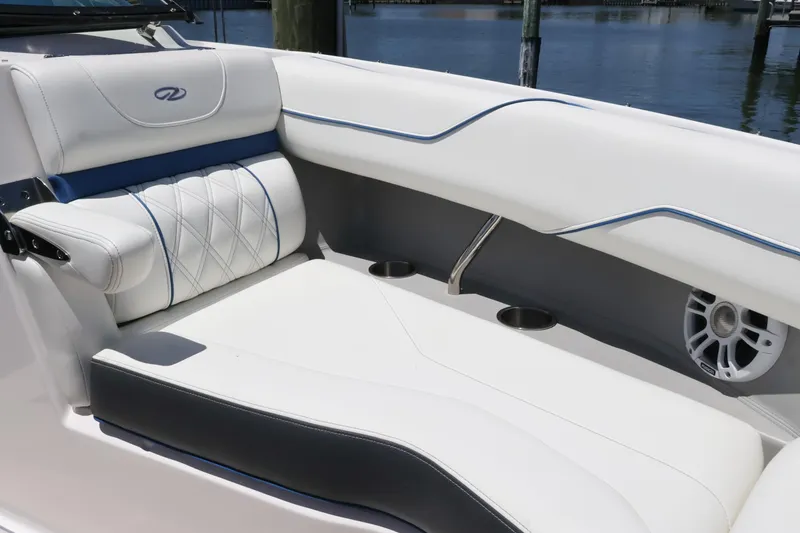 Slide: The Image of Luxurious seating on a 2020 Regal LX4 boat, featuring white upholstery and cup holders. - 35