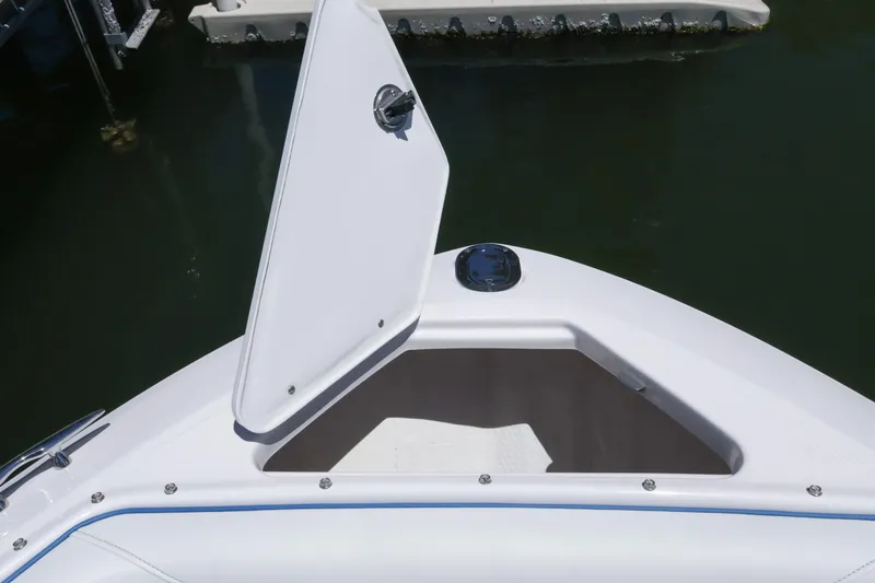 Slide: The Image of Open storage compartment on 2020 Regal LX4 boat, docked on calm water. - 39