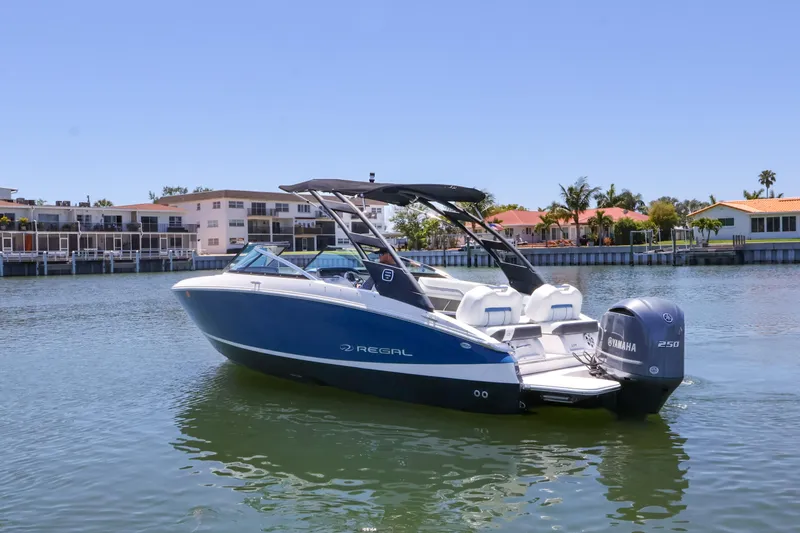 Slide: The Image of 2020 Regal LX4 boat with Yamaha engine on calm water near waterfront homes. - 4
