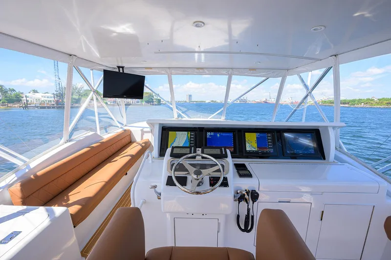 Slide: The Image of Helm of 2001 Hatteras 60 Convertible yacht with navigation screens and leather seating. - 49