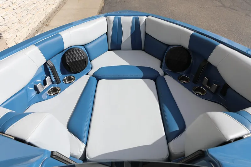 Slide: The Image of 2023 Malibu Wakesetter 22 LSV boat interior with blue and white seating, cup holders, and speakers. - 16
