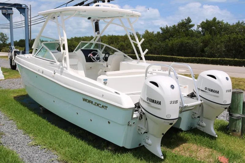Slide: The Image of 2026 World Cat 230 SD boat with twin Yamaha 115 engines, parked on grass. - 3
