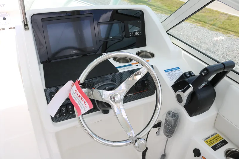 Slide: The Image of Helm of 2026 World Cat 230 SD boat with steering wheel and control panel. - 7