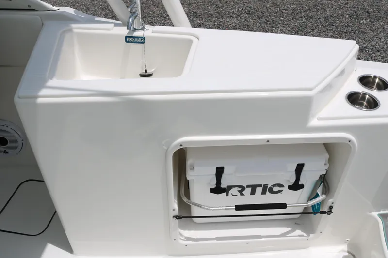 Slide: The Image of 2026 World Cat 230 SD boat interior with sink, cooler, and cup holders. - 13
