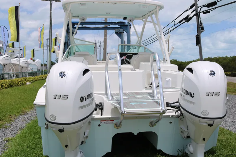 Slide: The Image of 2026 World Cat 230 SD boat with dual Yamaha 115 engines, docked outdoors. - 2