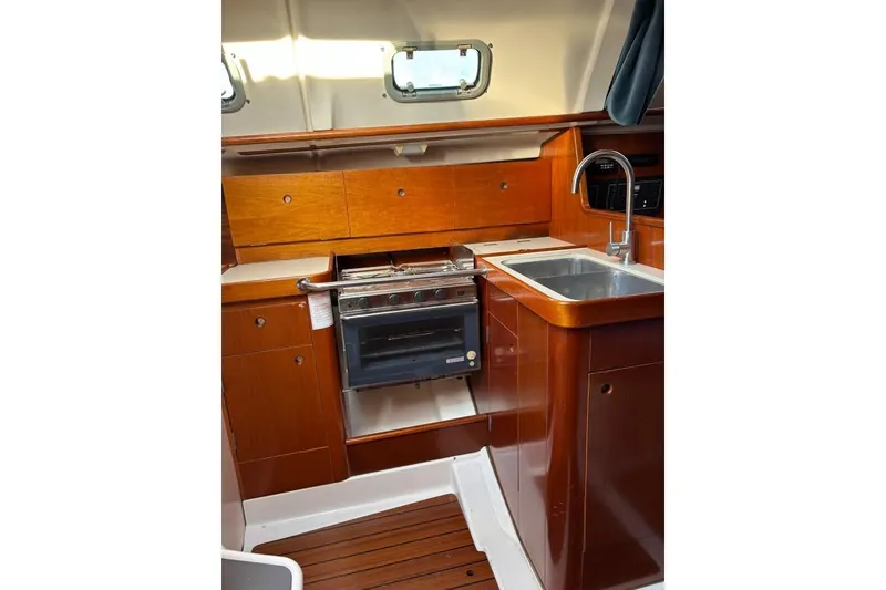 Slide: The Image of Interior of 1995 Beneteau Oceanis 321 yacht kitchen with wooden cabinetry and stainless steel sink. - 11