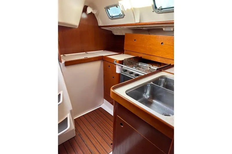 Slide: The Image of Interior of 1995 Beneteau Oceanis 321 yacht kitchen with wood finish and stainless steel sink. - 12