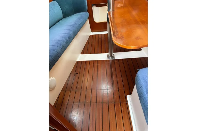 Slide: The Image of Interior of 1995 Beneteau Oceanis 321 sailboat with wooden flooring and blue seating. - 14
