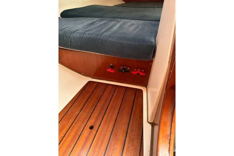 Slide: The Image of Interior view of a 1995 Beneteau Oceanis 321 sailboat with wooden flooring and cushioned seating. - 15
