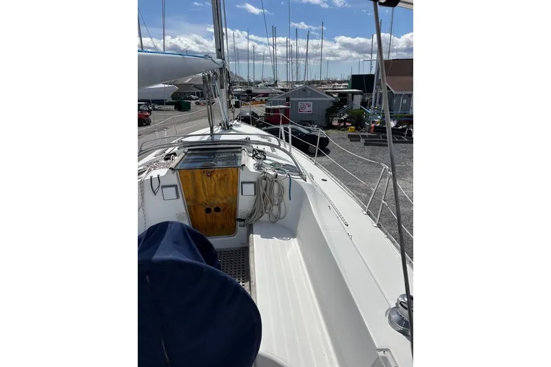 Slide: The Image of 1995 Beneteau Oceanis 321 sailboat docked, showcasing deck and cabin entrance. - 6
