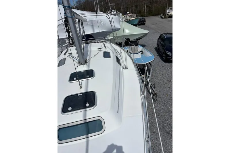 Slide: The Image of 1995 Beneteau Oceanis 321 sailboat deck view, parked on gravel lot. - 8
