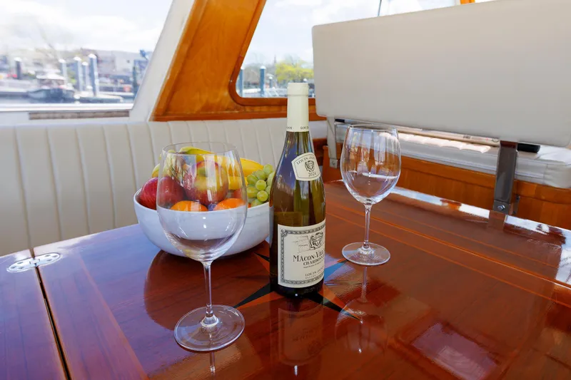 Slide: The Image of Luxurious Eastbay 49 yacht interior with wine, glasses, and fruit bowl on polished table. - 18