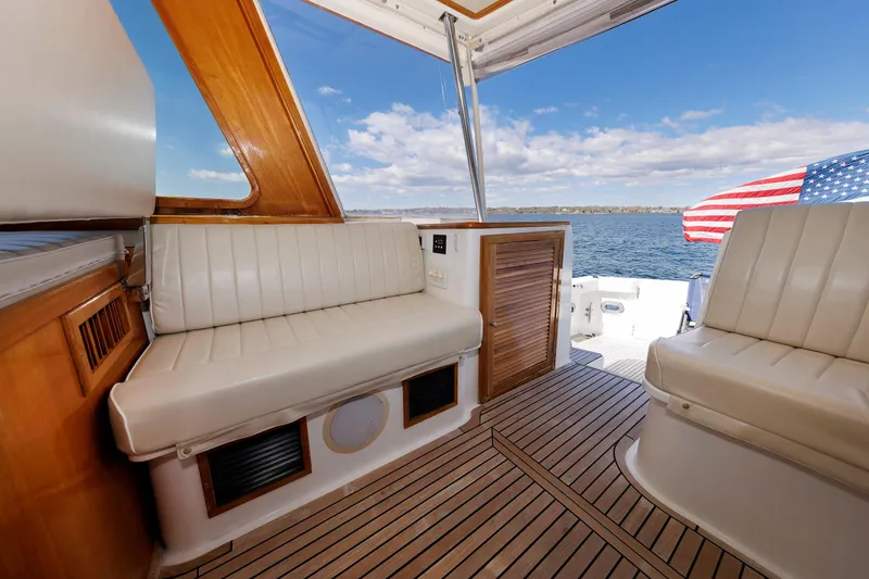 Slide: The Image of Interior of 2000 Eastbay 49 yacht with leather seating and American flag on deck. - 20