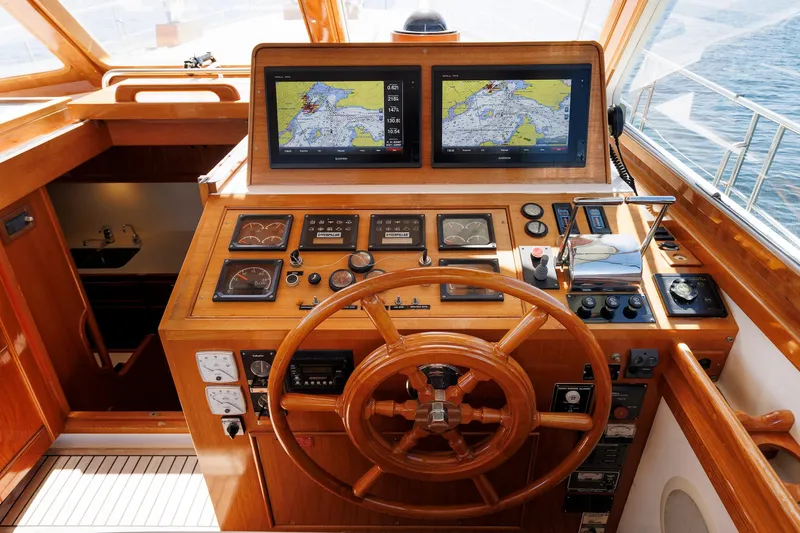 Slide: The Image of Helm of 2000 Eastbay 49 yacht with navigation screens and wooden steering wheel. - 24