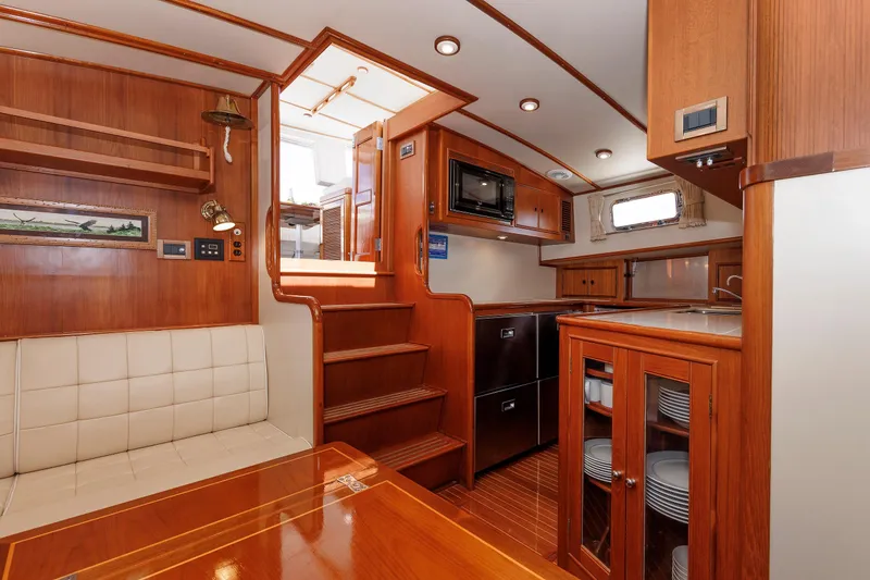 Slide: The Image of Luxurious 2000 Eastbay 49 yacht interior with wood finish, kitchenette, and seating area. - 29