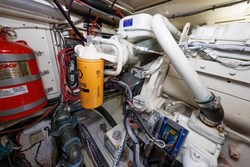 Slide: The Image of Engine room of a 2000 Eastbay 49 boat, featuring mechanical components and wiring. - 37
