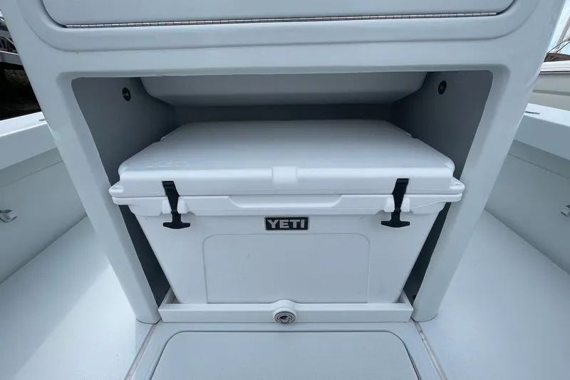 Slide: The Image of 2025 Hell's Bay Estero boat with a Yeti cooler in storage compartment. - 16