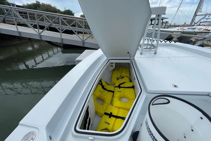Slide: The Image of 2025 Hell's Bay Estero boat with open storage compartment and yellow life jackets. - 19