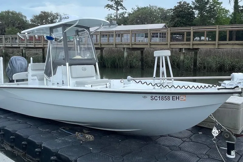 Slide: The Image of 2025 Hell's Bay Estero boat docked by a wooden pier, showcasing sleek design. - 3