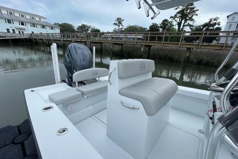Slide: The Image of 2025 Hell's Bay Estero boat interior with seating and motor, dockside view. - 6