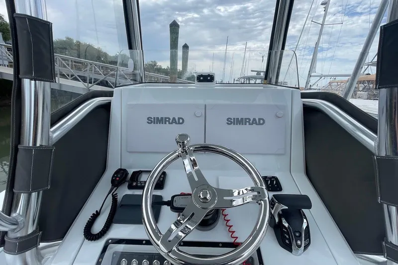 Slide: The Image of 2025 Hell's Bay Estero boat dashboard with Simrad electronics and steering wheel. - 9