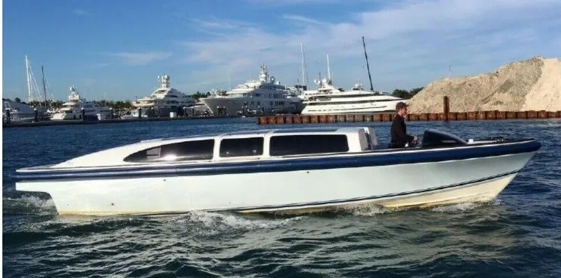 The Image of 2008 Goetz Custom Boats 33' Limo Tender cruising in a marina with yachts in the background. - 0