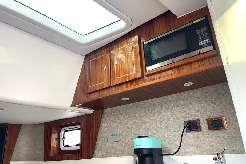 Slide: The Image of 2024 HCB 48 Campeon yacht interior with microwave, wooden cabinets, and modern appliances. - 21