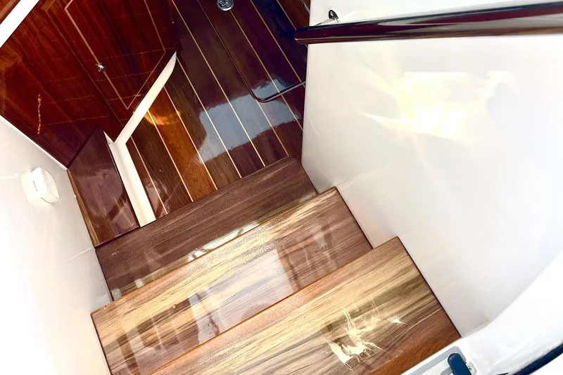 Slide: The Image of 2024 HCB 48 Campeon boat interior with polished wooden stairs and sleek design. - 17