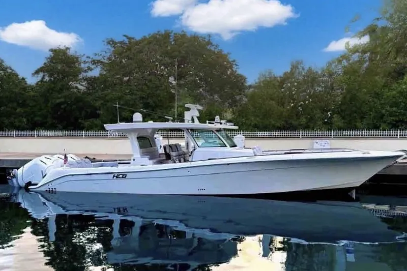The Image of 2024 HCB 48 Campeon boat docked on calm water under blue sky. - 0