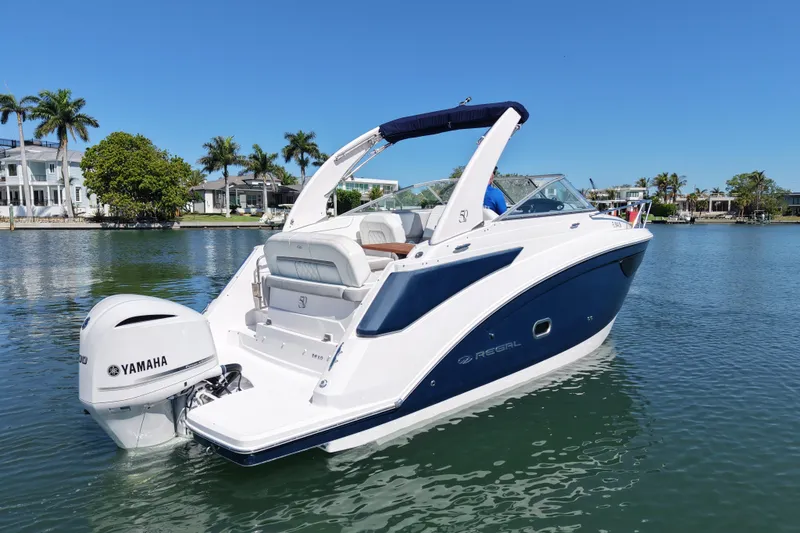 The Image of 2020 Regal 26 XO boat with Yamaha engine on calm water, surrounded by palm trees. - 0