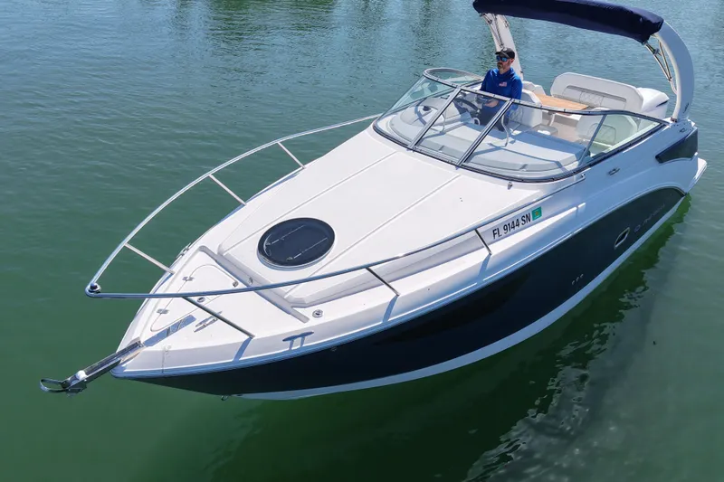Slide: The Image of 2020 Regal 26 XO boat cruising on calm water with a person at the helm. - 10