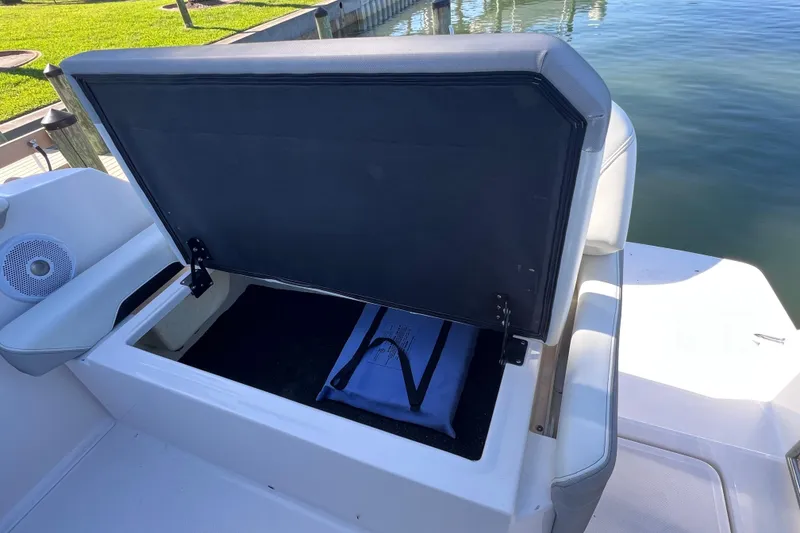 Slide: The Image of Open storage compartment on a 2020 Regal 26 XO boat by the water. - 17