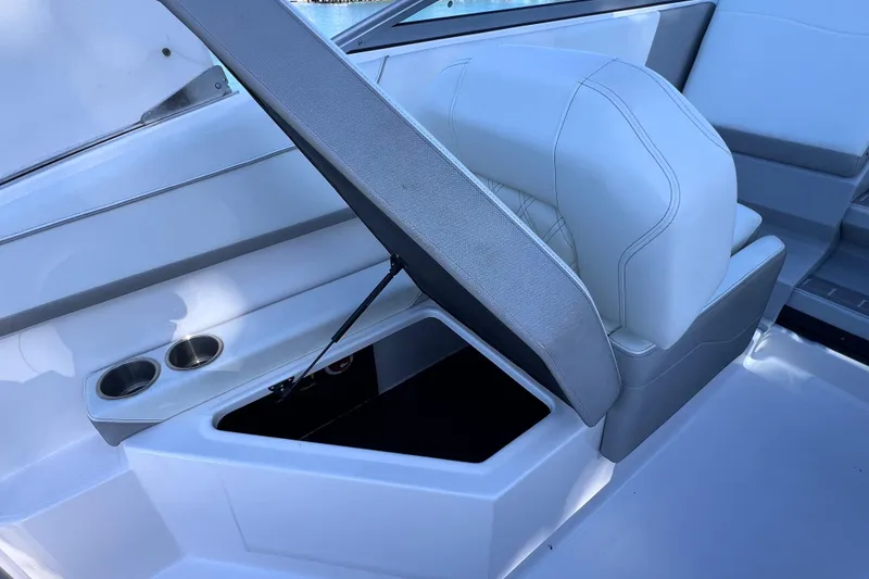 Slide: The Image of 2020 Regal 26 XO boat interior with open storage compartment and cup holders. - 22