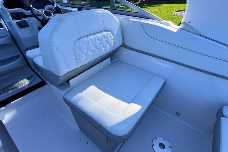 Slide: The Image of 2020 Regal 26 XO boat interior with white cushioned seating and steering wheel. - 25