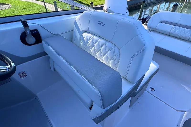 Slide: The Image of 2020 Regal 26 XO boat interior with white cushioned seating and steering controls. - 27