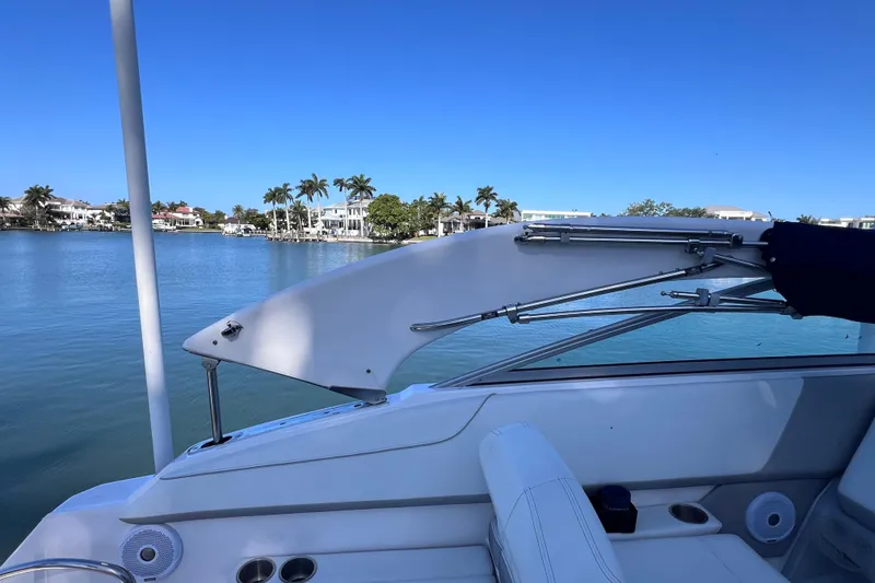 Slide: The Image of 2020 Regal 26 XO boat on calm water with scenic waterfront view. - 29