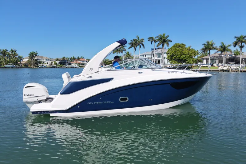 Slide: The Image of 2020 Regal 26 XO boat on calm water with palm trees in the background. - 3